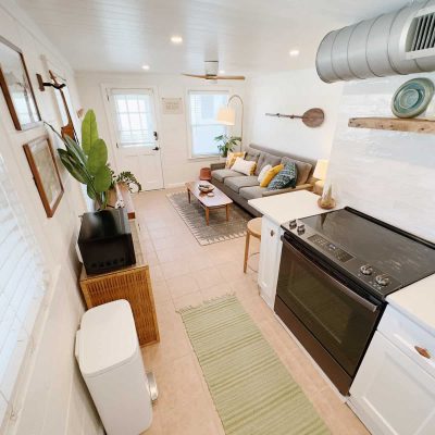 A beautiful view of the open-concept kitchen, with its sleek countertops, modern appliances, and elegant lighting, seamlessly blending into the inviting and cozy living room space beyond